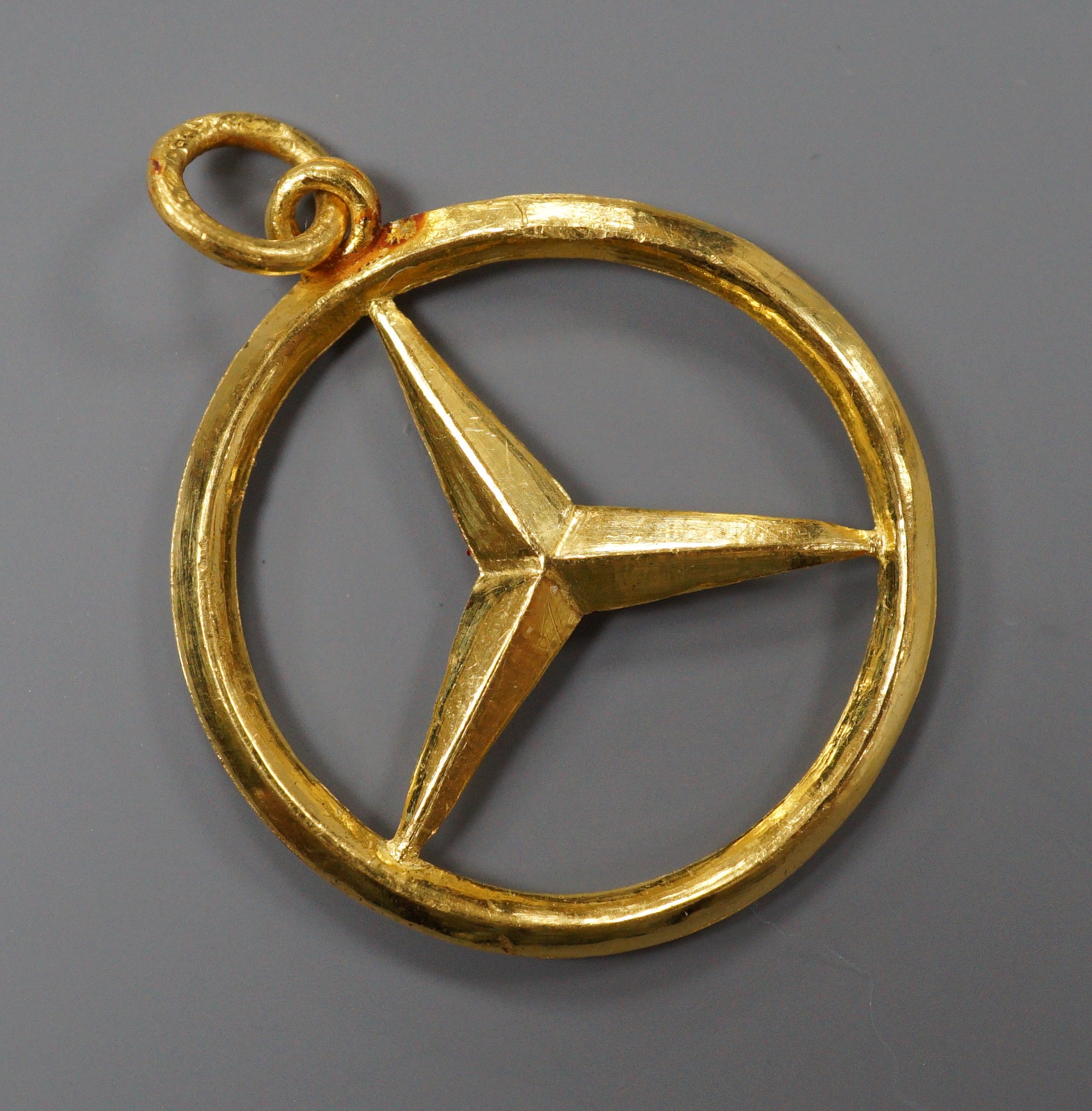 A modern Hong Kong yellow metal Mercedes Benz car badge pendant, 29mm, 8.5 grams.